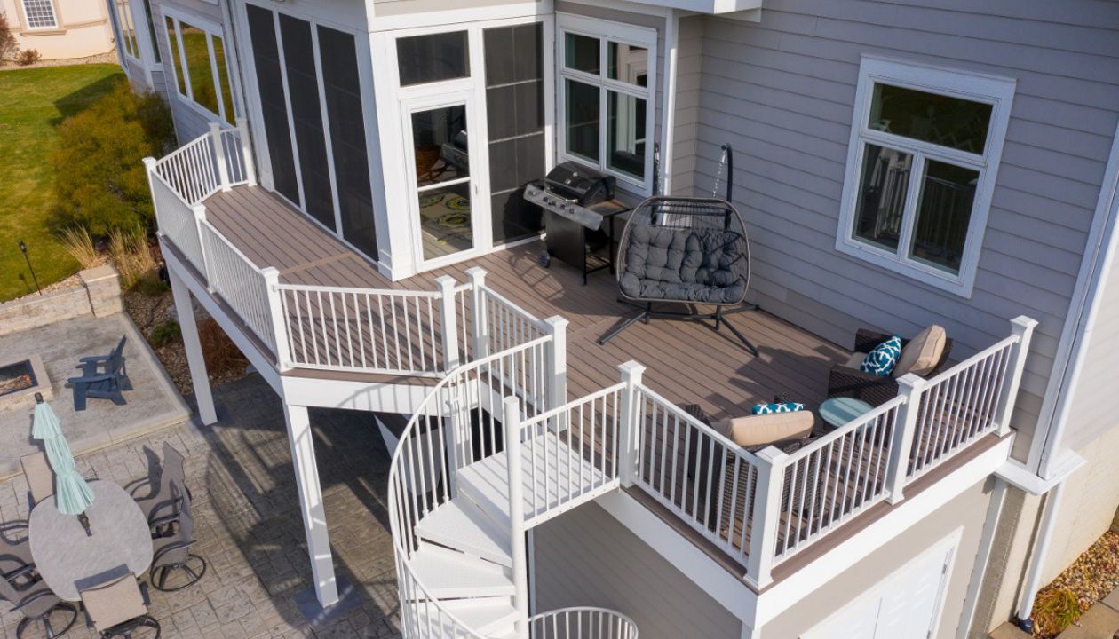Trex Enhanced Rocky Harbor decking with white Trex Signature railing and Trex spiral stairs