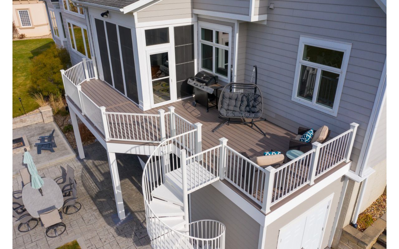 Trex Enhanced Rocky Harbor decking with white Trex Signature railing and Trex spiral stairs
