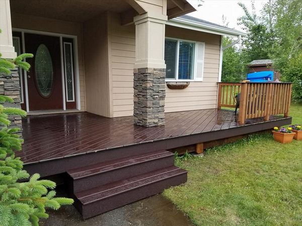 Trex Select Decking in woodland brown. Standard wood railings with Trex top cap. *note customer chose to center stairs with doorway and not the asphalt walkway.
