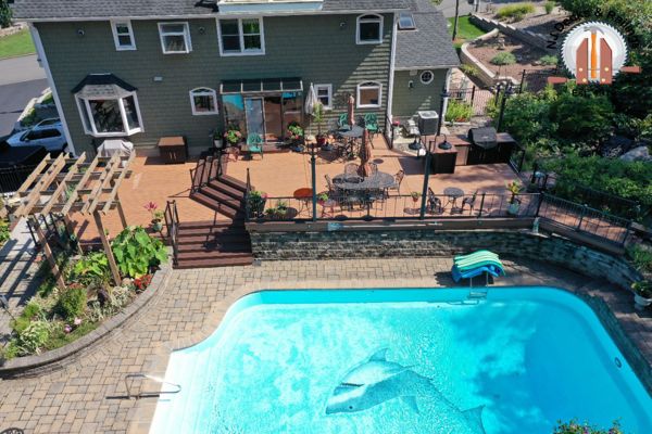 Trex Transcend Tiki Torch with Lava Rock border, Vertical cable railings and a builtin kitchen with custom concrete countertops.