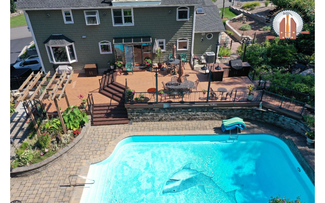 Trex Transcend Tiki Torch with Lava Rock border, Vertical cable railings and a builtin kitchen with custom concrete countertops.