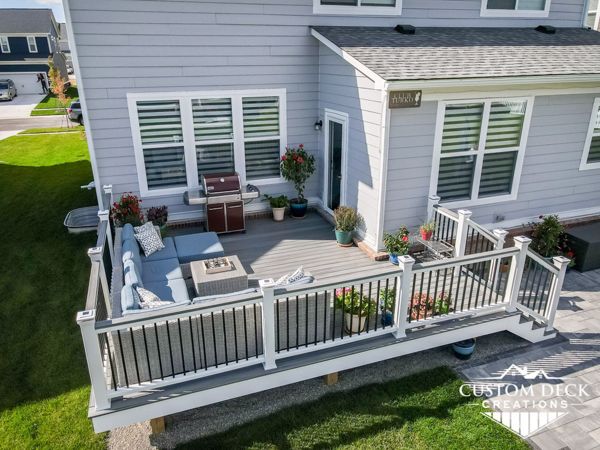 Trex Transcend Island Mist decking built with Trex Signature aluminum railing in black and white Trex composite railing posts. Matching cocktail board added to railing. Solar powered railing post cap lights.