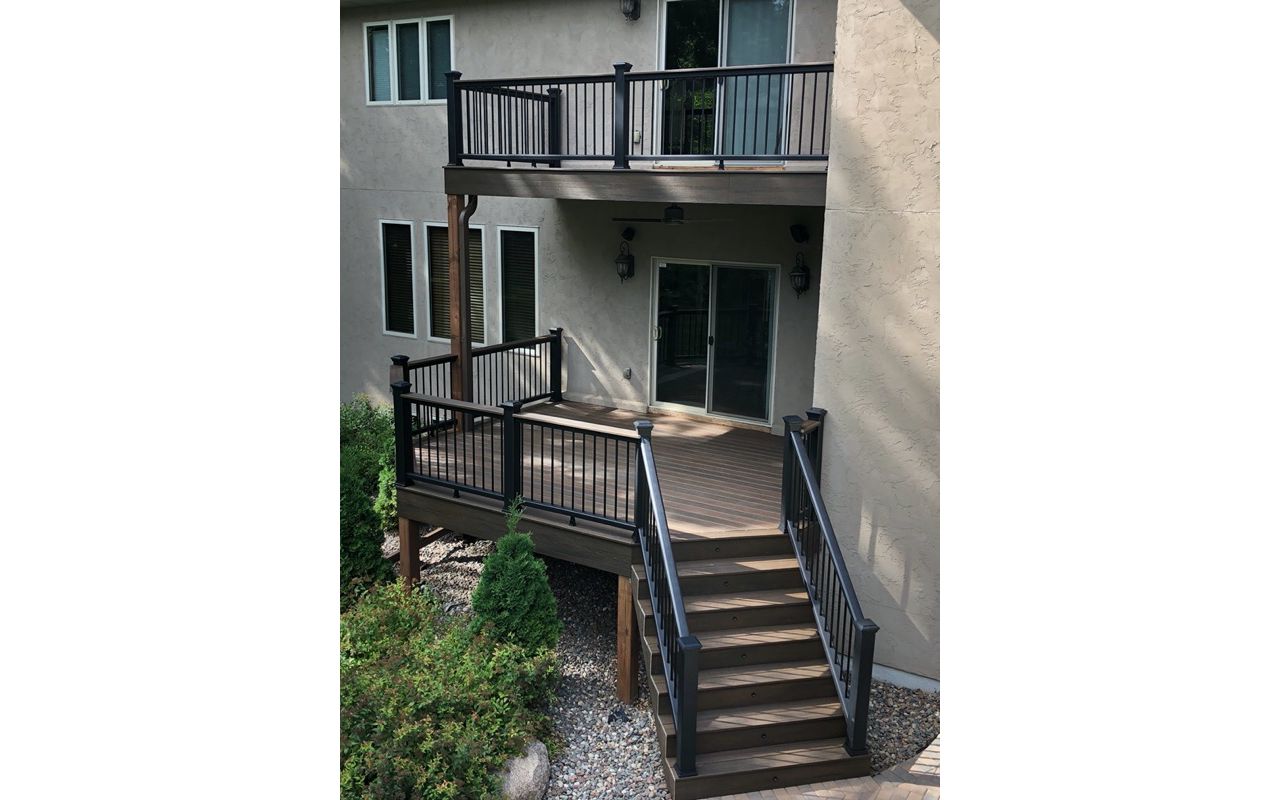 Trex/Transcend/Spiced Rum Composite Decking with Trex/Transcend Universal Composite Railing (black with round aluminum balusters) and Trex/Transcend Spiced Rum Composite Decking with Trex/Post Cap Accent Lighting and Trex Stair Accent Lighting