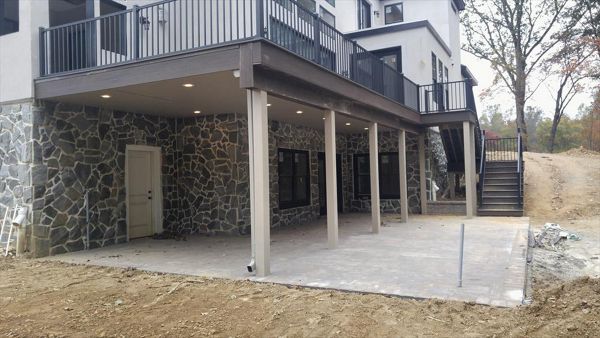 Trex RainEscape w/ finished ceiling, Signature Charcoal Black Railing, Trex Outdoor Lighting and Trex Transcend Lava Rock decking