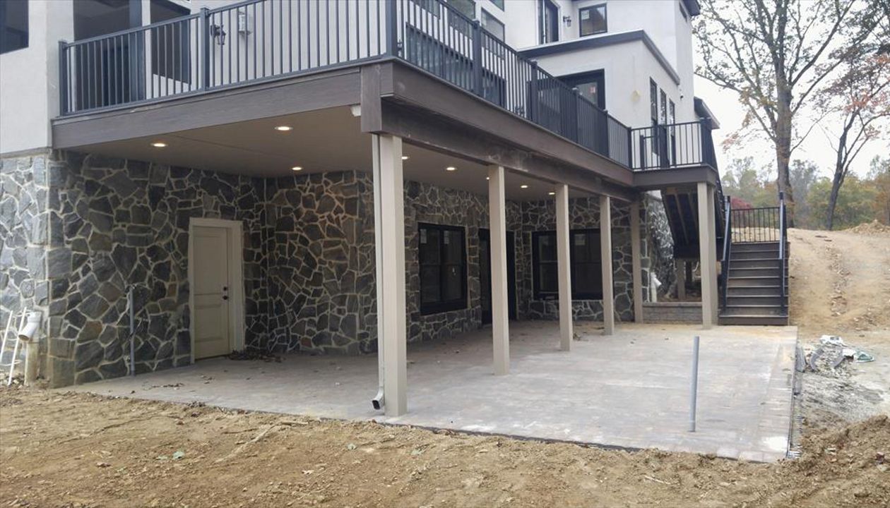 Trex RainEscape w/ finished ceiling, Signature Charcoal Black Railing, Trex Outdoor Lighting and Trex Transcend Lava Rock decking