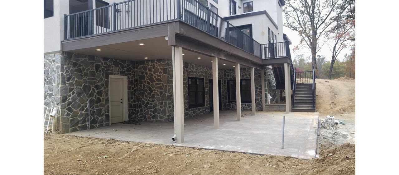 Trex RainEscape w/ finished ceiling, Signature Charcoal Black Railing, Trex Outdoor Lighting and Trex Transcend Lava Rock decking