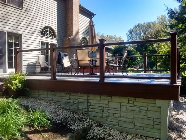 Glass panels in lieu of balusters complete this expanded deck in Island Lake, IL.  Transcend decking with a 2 tone look and we added PVC fence panels to enclose the underside of the deck for storage.