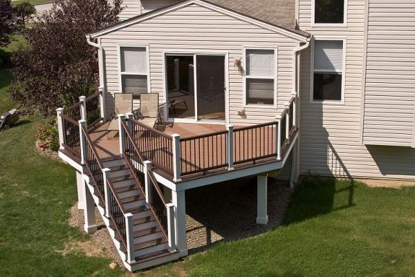 Elevated deck featuring Trex Enhance Beach Dune decking  with Vintage Lantern double boarder. The Trex Transcend Two-Tone Vintage Lantern railing and wrapped support columns sets this deck apart.