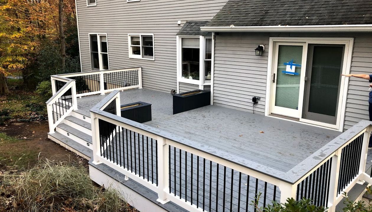 Trex Select Pebble Gray Composite Decking with White Vinyl Railing + Round Black Aluminum Balusters + matching Pebble Gray Cocktail Rail and two Composite Planters