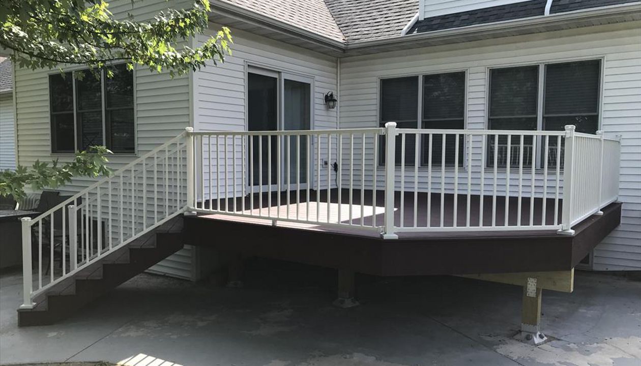 Trex Select Madeira decking with Trex Signature aluminum white railings and post cap lighting by GE Contracting LLC in Appleton, WI