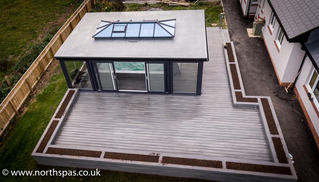 A sea of Grey Island Mist surrounding a swim spa with decorative planters