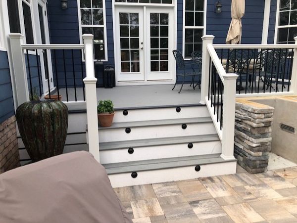 Trex Select Pebble Grey decking is a great match to the dark blue siding & white trim
