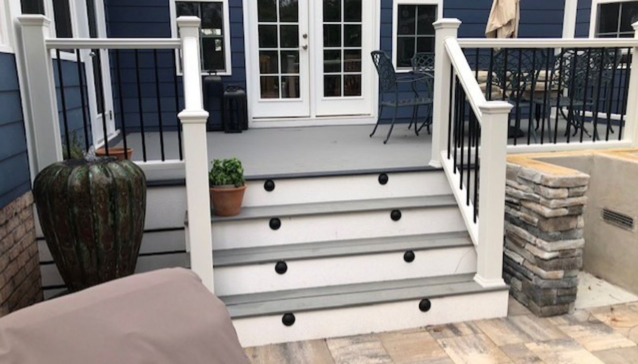 Trex Select Pebble Grey decking is a great match to the dark blue siding & white trim