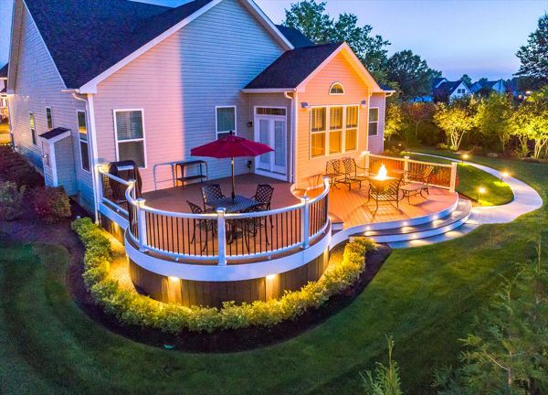 Custom Curved Trex Transcend deck in Tree House with white Trex Trascend railing with aluminum balusters. Trex Low voltage LED cap lights