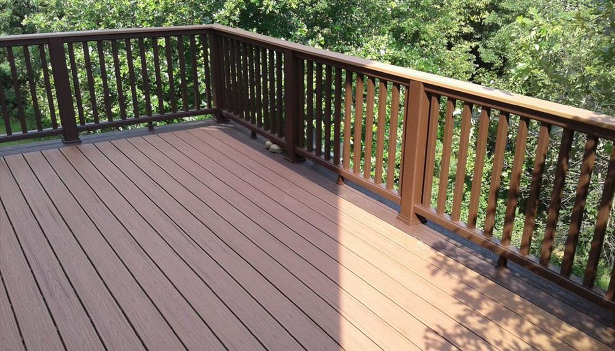 Trex Transcend Tiki Torch decking with a Vintage Lantern double picture frame. The Transcend Vintage Lantern railing features black aluminum balusters and a Tiki Torch cocktail rail cap.