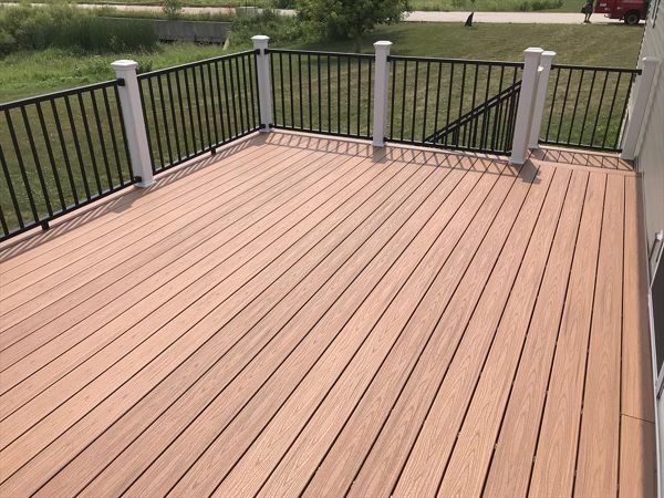 Trex Transcend Tiki Torch decking with Signature black aluminum rails and white posts by GE Contracting LLC in Greenville, WI