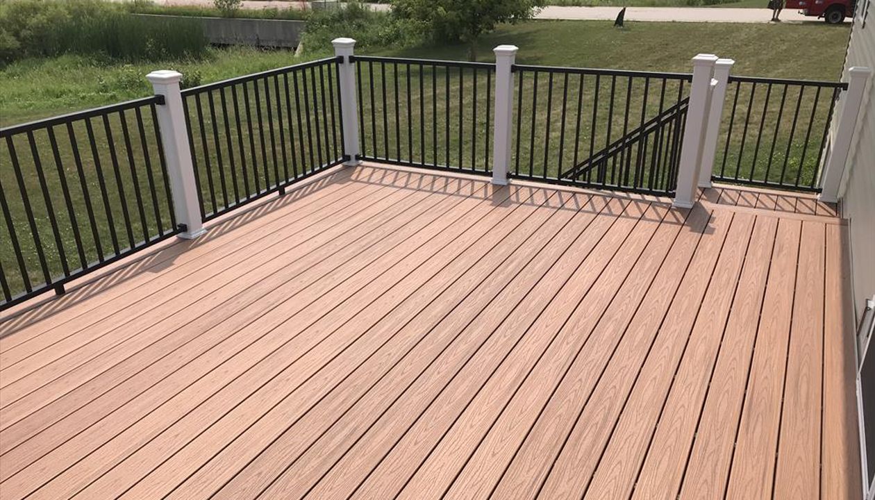 Trex Transcend Tiki Torch decking with Signature black aluminum rails and white posts by GE Contracting LLC in Greenville, WI