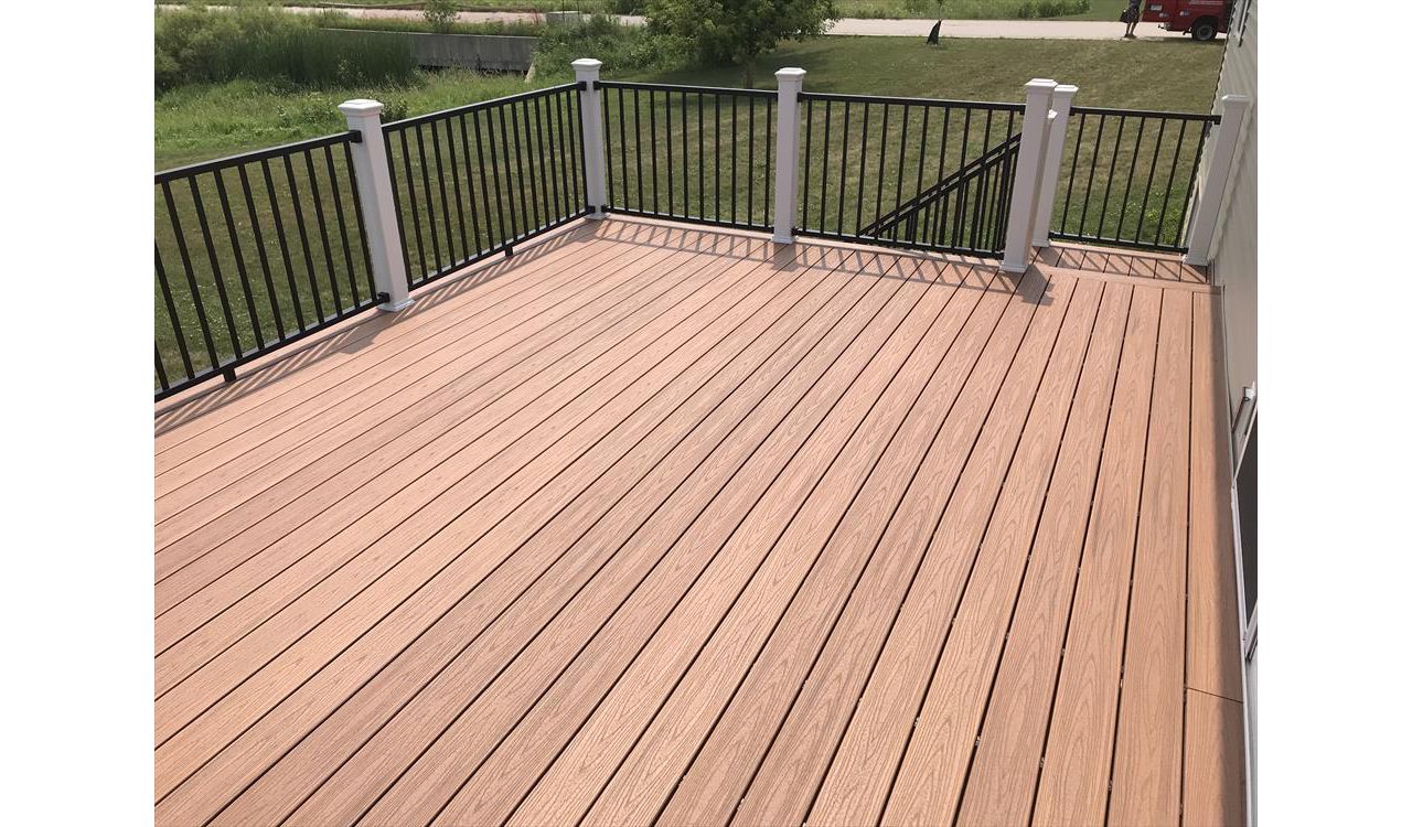 Trex Transcend Tiki Torch decking with Signature black aluminum rails and white posts by GE Contracting LLC in Greenville, WI