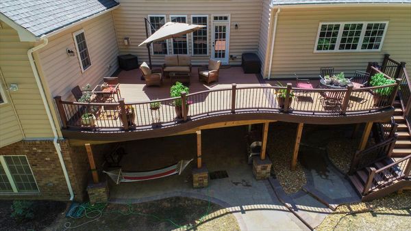 Trex Transcend Decking in Tiki Torch color installed using Trex Hidden Fasteners.  Trex Custom Curve railing in Vintage Lantern with black aluminum balusters.  Installed by Prince William Home Improvement in Fredericksburg, VA  PWHI