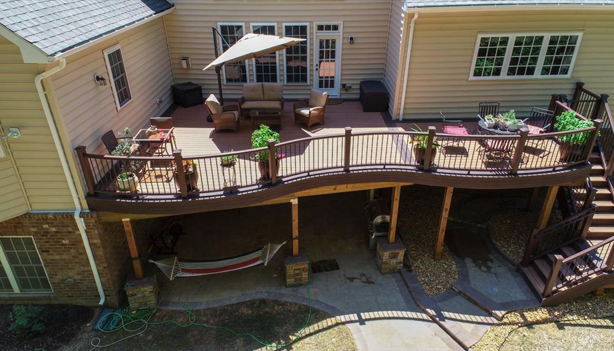 Trex Transcend Decking in Tiki Torch color installed using Trex Hidden Fasteners.  Trex Custom Curve railing in Vintage Lantern with black aluminum balusters.  Installed by Prince William Home Improvement in Fredericksburg, VA  PWHI