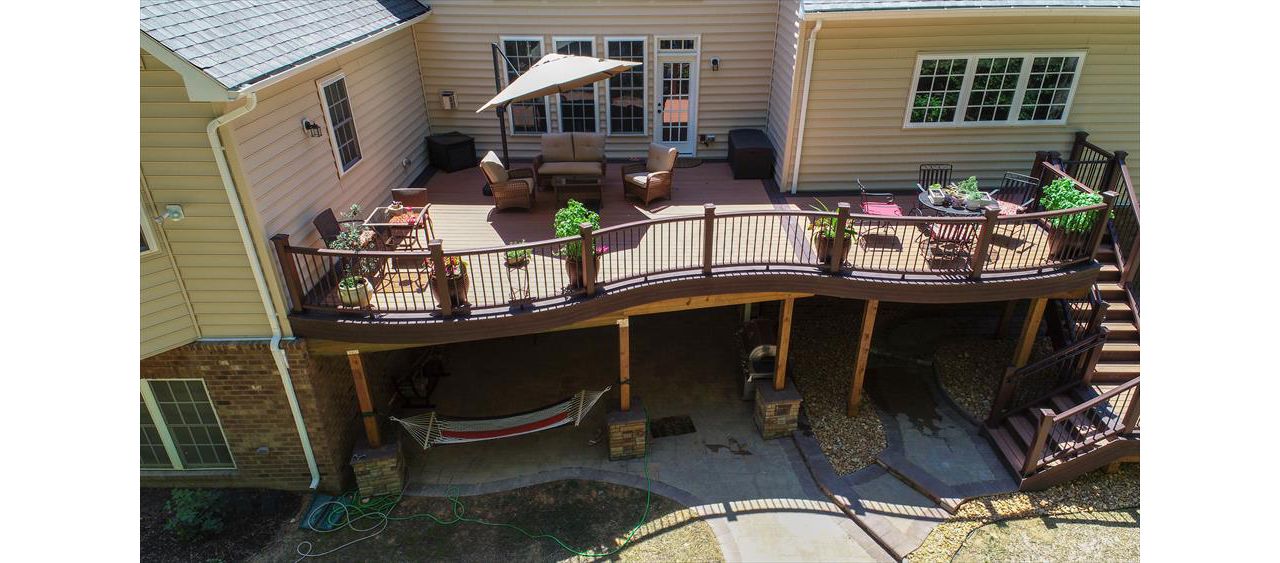 Trex Transcend Decking in Tiki Torch color installed using Trex Hidden Fasteners.  Trex Custom Curve railing in Vintage Lantern with black aluminum balusters.  Installed by Prince William Home Improvement in Fredericksburg, VA  PWHI