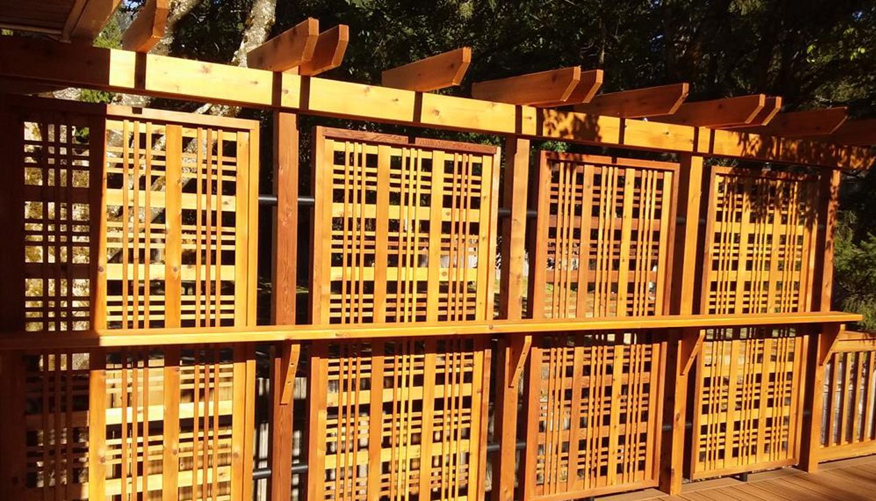 Trex Contour Torino Brown with Torino Brown border and privacy rail with drink bar done in appearance grade pressure treated and stained cedar.