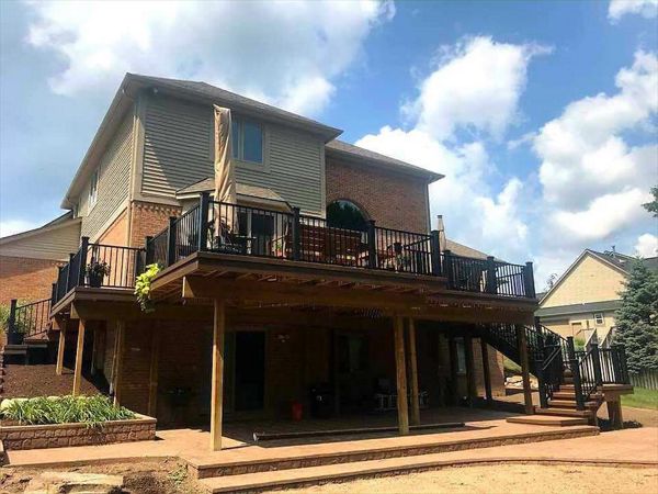 Spiced rum deck with Lava Rock border, black trex post sleeves, black signature rail, and big open spaces underneath from the GLU-Laminate Beam addition