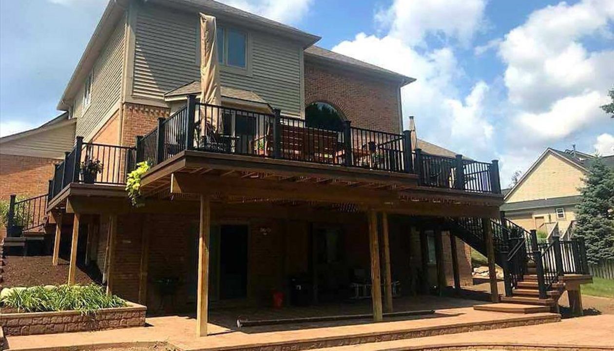 Spiced rum deck with Lava Rock border, black trex post sleeves, black signature rail, and big open spaces underneath from the GLU-Laminate Beam addition