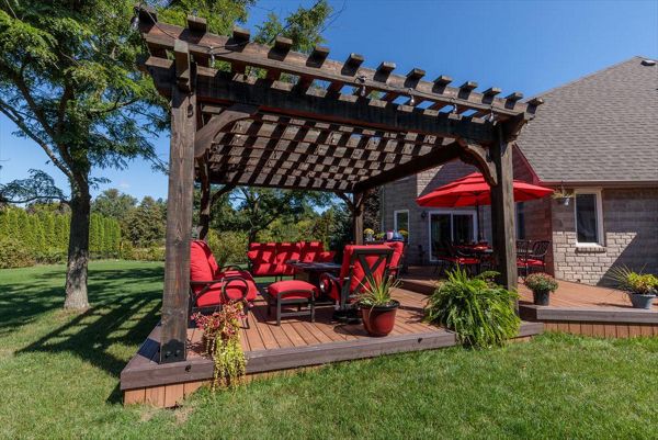 Brown composite decking using Transcend Tiki Torch with Vintage Lantern Trim and custome wood pergola - Orangeville, Caledon, Alliston, Bolton, Schomberg, Nobelton