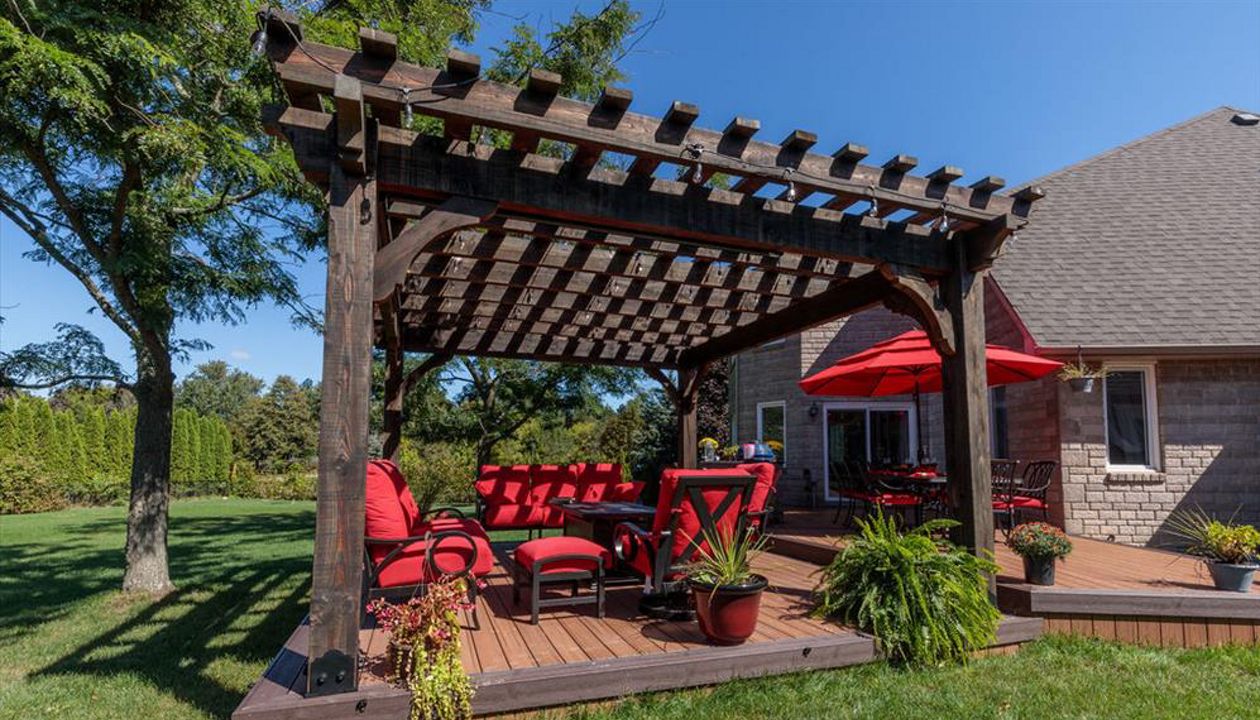 Brown composite decking using Transcend Tiki Torch with Vintage Lantern Trim and custome wood pergola - Orangeville, Caledon, Alliston, Bolton, Schomberg, Nobelton