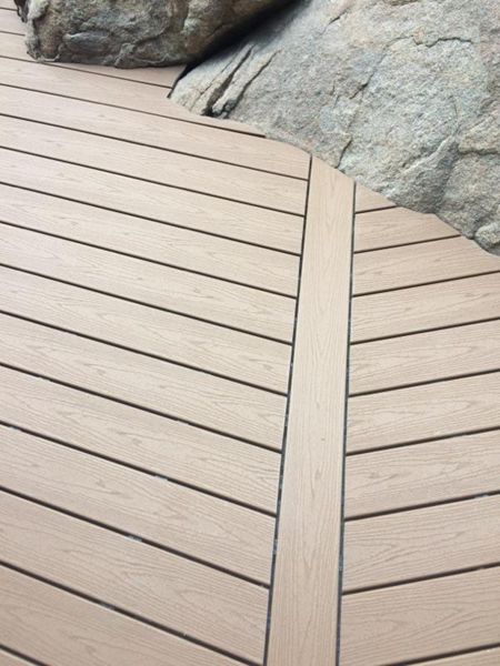 Prescott AZ. Tiki Torch with groove, hidden clips. Trex joist tape. Scribed around boulders.