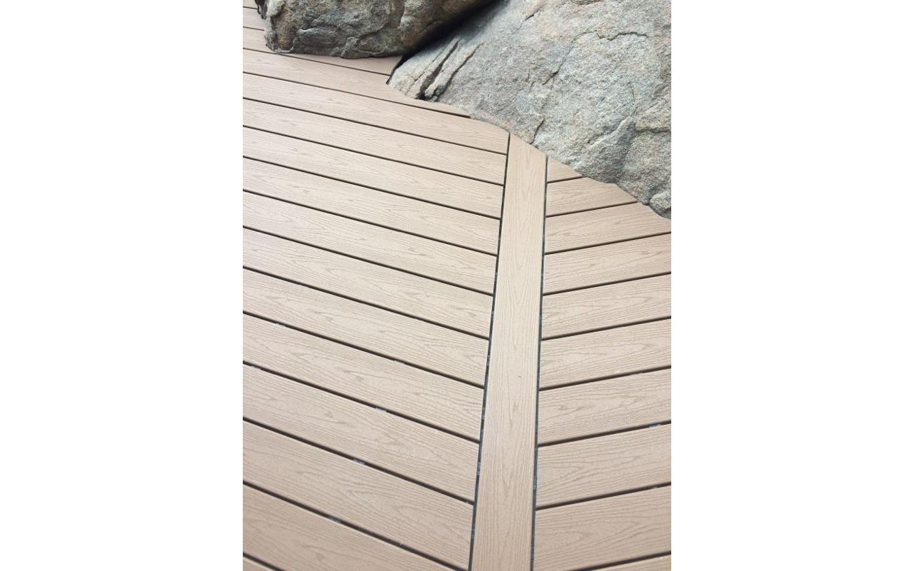 Prescott AZ. Tiki Torch with groove, hidden clips. Trex joist tape. Scribed around boulders.