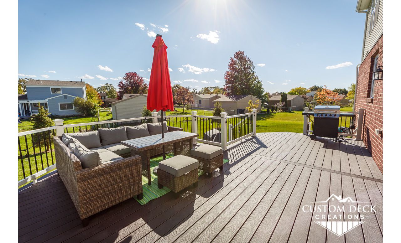 Trex Select Woodland Brown decking with Trex Select composite white railing and black round aluminum balusters.