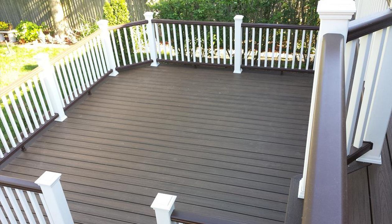 Trex Transcend decking in Spiced Rum with a Vintage Lantern border. Railings have Vintage Lantern top and bottom rails with Classic White posts, caps and balusters.