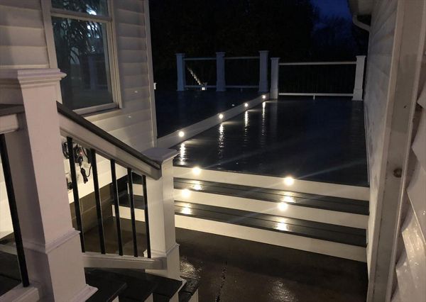 Home entrance way all lit up with in stair lighting giving this backyard a beautiful glow.