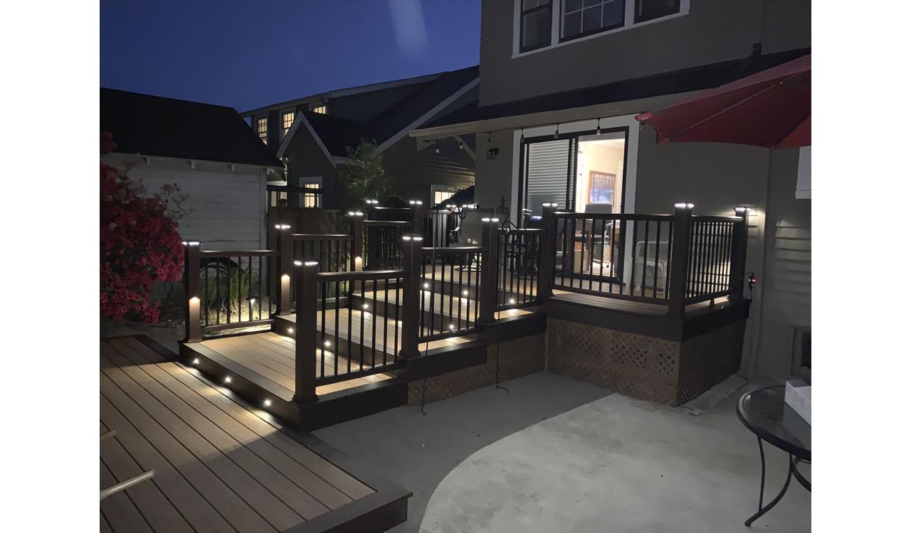 Trex Transcend Tiki Torch decking with Vintage Lantern boarder, Transcend Vintage Lantern railing with metal balusters and Trex lighting