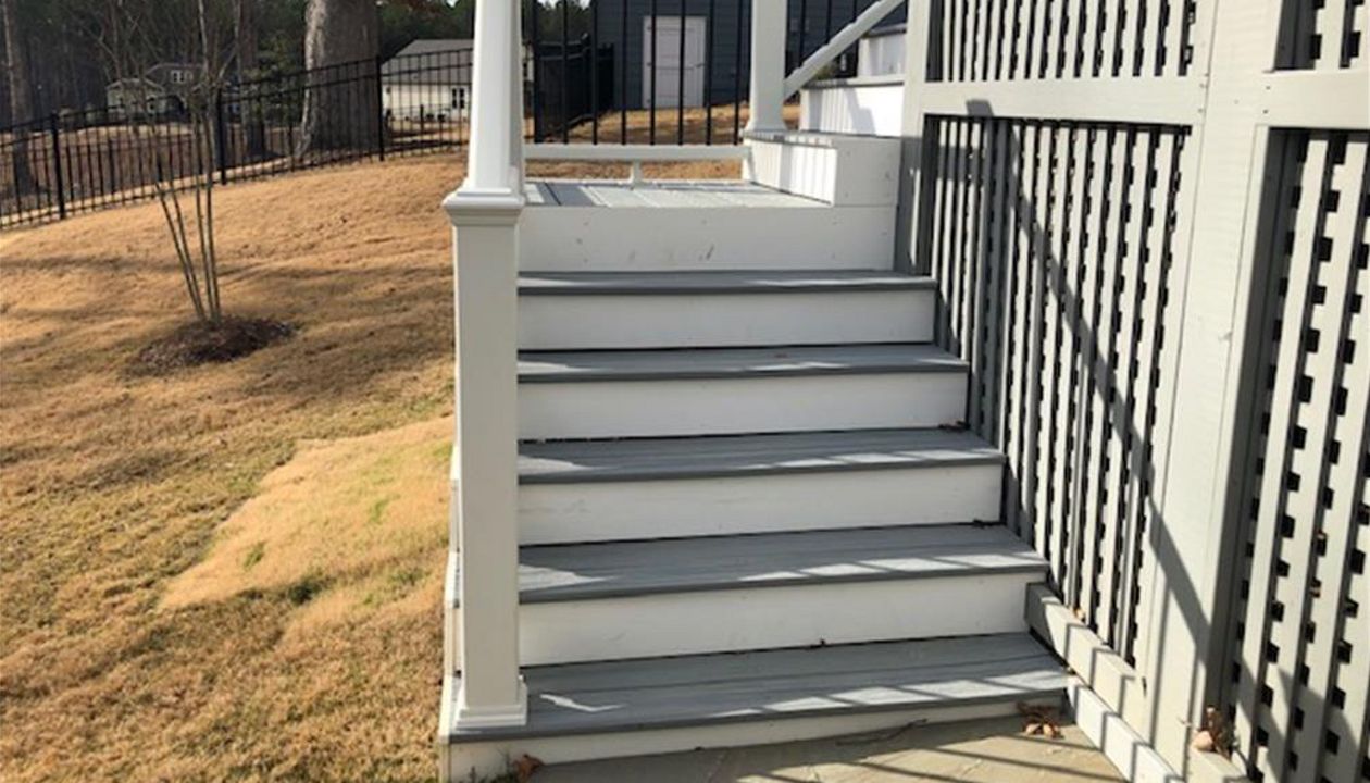 Trex Enhance Naturals Foggy Wharf deck with Transcend white handrails welcomes you to the outdoor living space