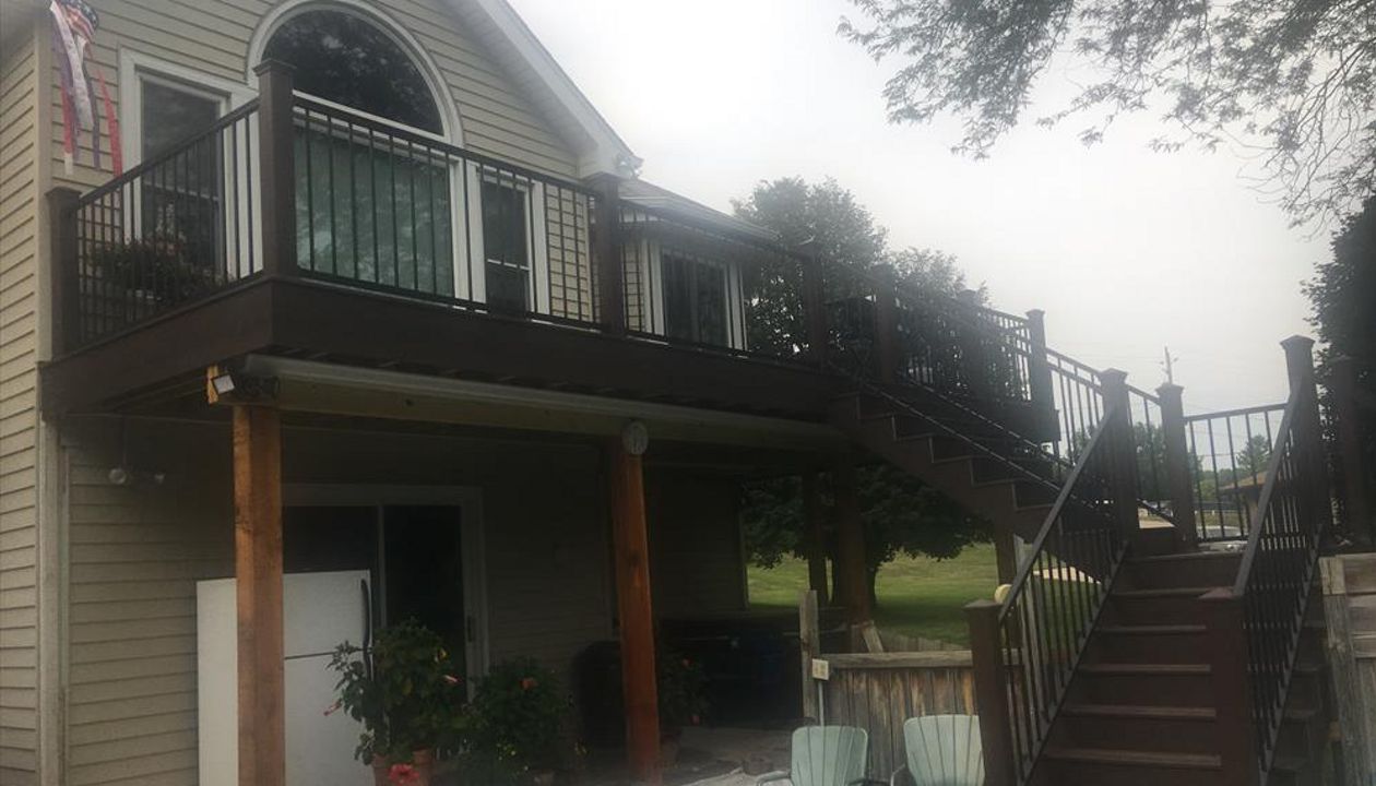 Rear deck with Trex Transcends Spiced Rum and Vintage Lantern border and fascia. Main deck also has Rain Escapes to protect the hot tub.  New steps spit to yard and pool deck