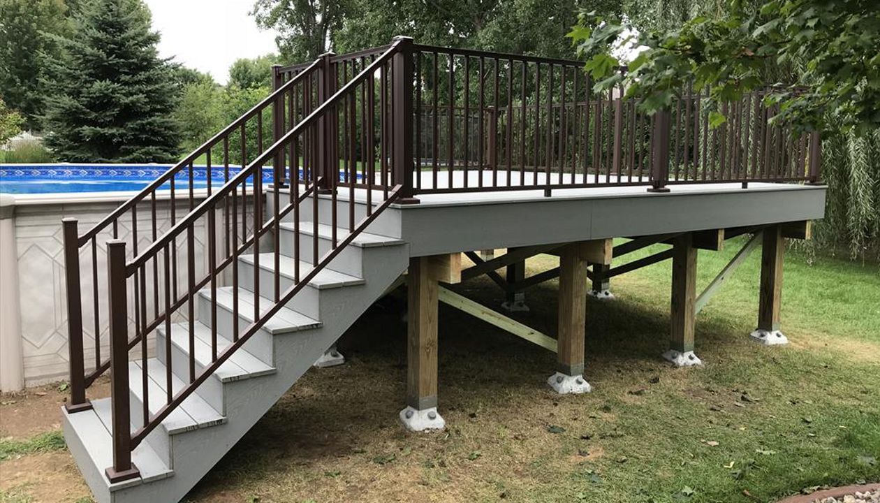 Trex pool deck in Select Pebble Gray decking with Trex Signature bronze aluminum railings by GE Contracting LLC in DePere, WI
