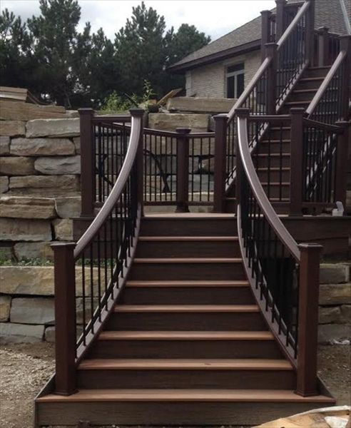 This custom deck has Trex transcends tree house decking, Trex transcends vintage lantern railing with black aluminum balusters. This custom curved staircase is located in Salem township...