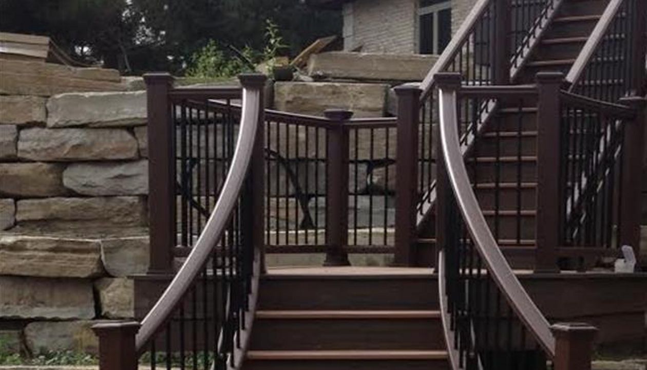 This custom deck has Trex transcends tree house decking, Trex transcends vintage lantern railing with black aluminum balusters. This custom curved staircase is located in Salem township...