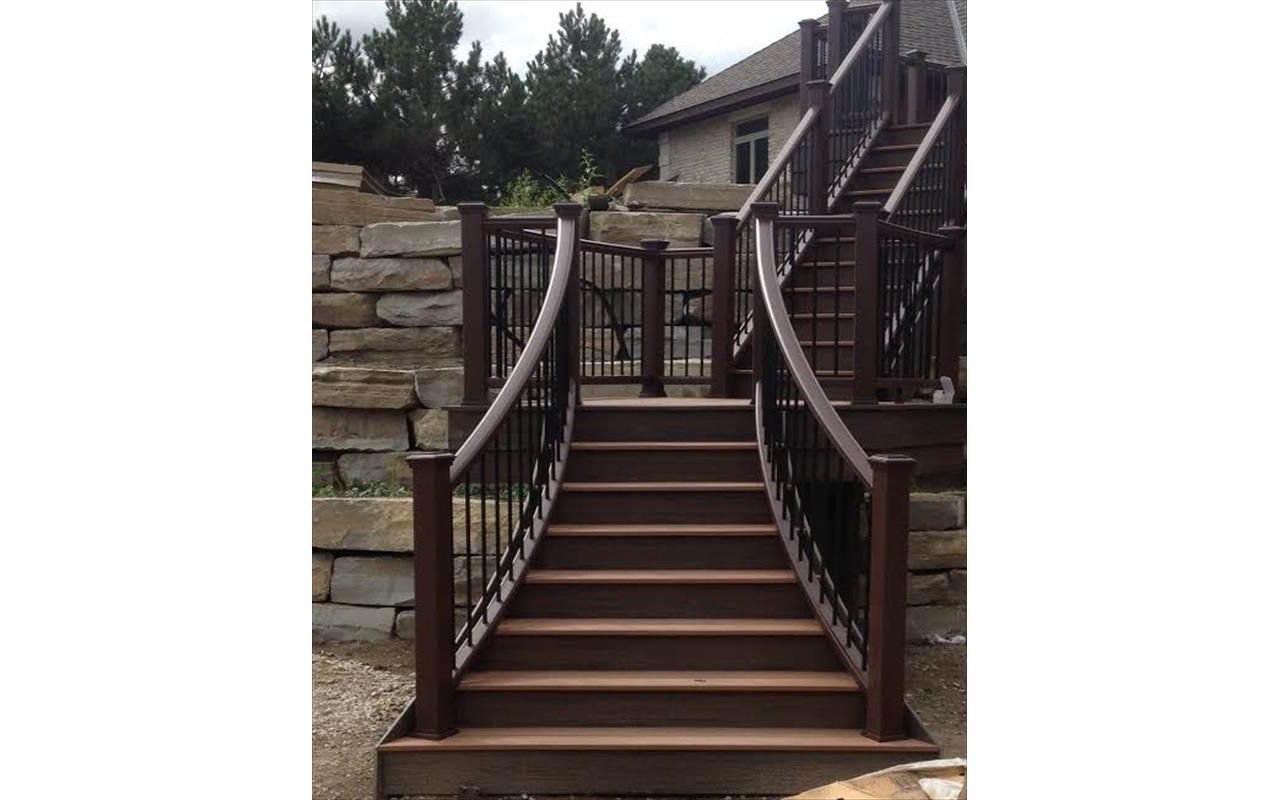This custom deck has Trex transcends tree house decking, Trex transcends vintage lantern railing with black aluminum balusters. This custom curved staircase is located in Salem township...