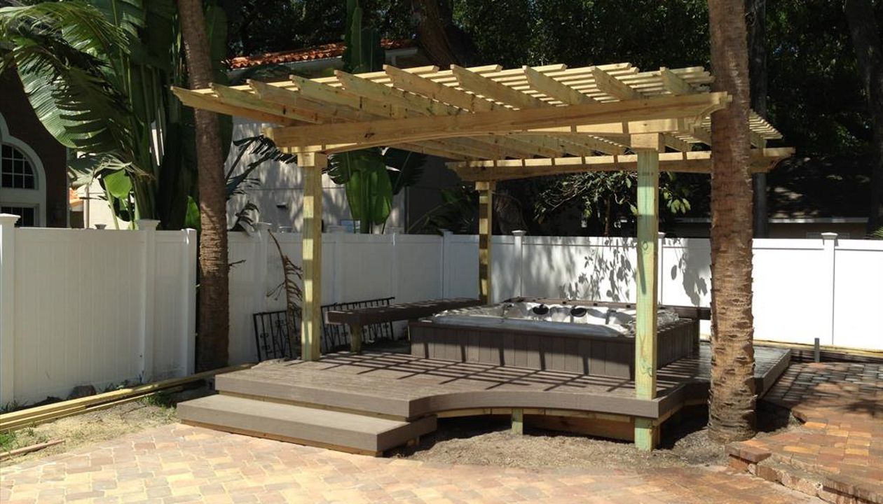 Here's an all in one package. Trex decking surrounds this custom built-in hot tub. There is seating on two sides to give the homeowner a place to relax in the shade of the pergola after a nice dip.