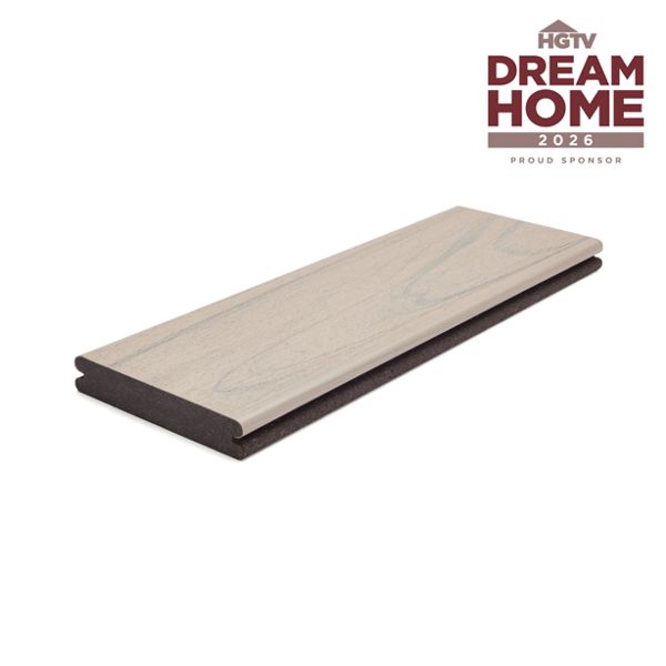 A single light wood composite deck board is displayed on a white background. The board features a subtle wood grain texture and a two-tone color scheme. In the upper right corner, the text 'HGTV Dream Home 2026 Proud Sponsor' is clearly visible, indicating a sponsorship. The overall presentation is clean and modern, emphasizing the product's finish and partnership.