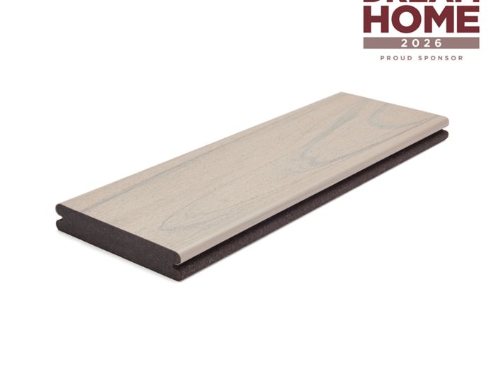 A single light wood composite deck board is displayed on a white background. The board features a subtle wood grain texture and a two-tone color scheme. In the upper right corner, the text 'HGTV Dream Home 2026 Proud Sponsor' is clearly visible, indicating a sponsorship. The overall presentation is clean and modern, emphasizing the product's finish and partnership.
