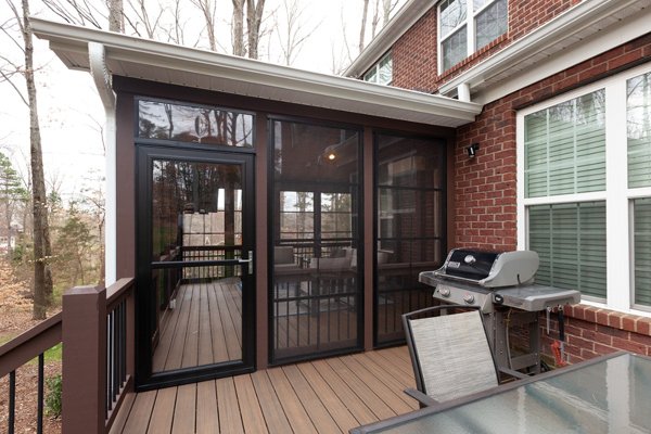 Screened in porch with decking in Trex Foggy Wharf with two Adirondack chairs looking out on the yard