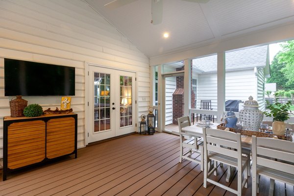 Screened in porch with decking in Trex Foggy Wharf with two Adirondack chairs looking out on the yard