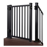 A black metal safety gate is installed between two sturdy posts on a raised deck. The gate features evenly spaced vertical bars and secure hinge hardware on one side. Brown wooden decking is visible beneath the gate, contrasting with the dark frame. The image is isolated on a white background, emphasizing the gate’s structure and clean lines.