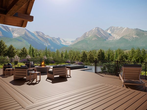 A beautiful deck made in Trex Signature Ocracoke with a gorgeous mountain range in the background and a forest of pines as far as the eye can see. 