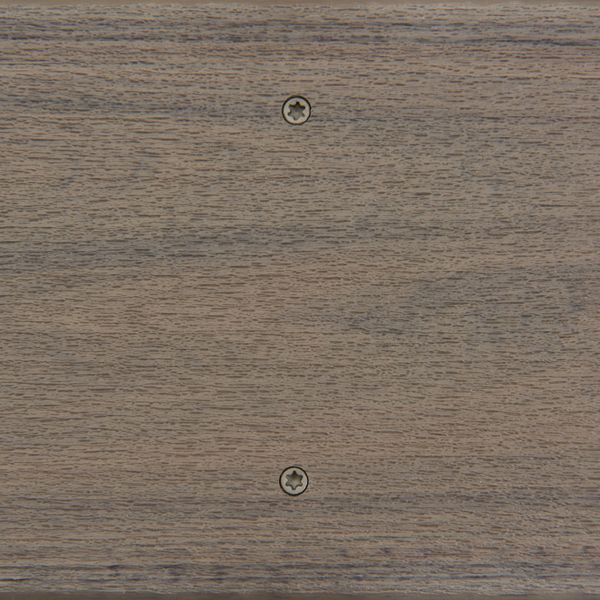 A detailed view of a wooden panel featuring a smooth, natural grain texture. Two metallic screws are clearly visible, aligned vertically near the center of the surface. The wood has a neutral brown tone, and the setting appears to be indoors with even lighting. No visible text, logos, or numbers are present in the image.